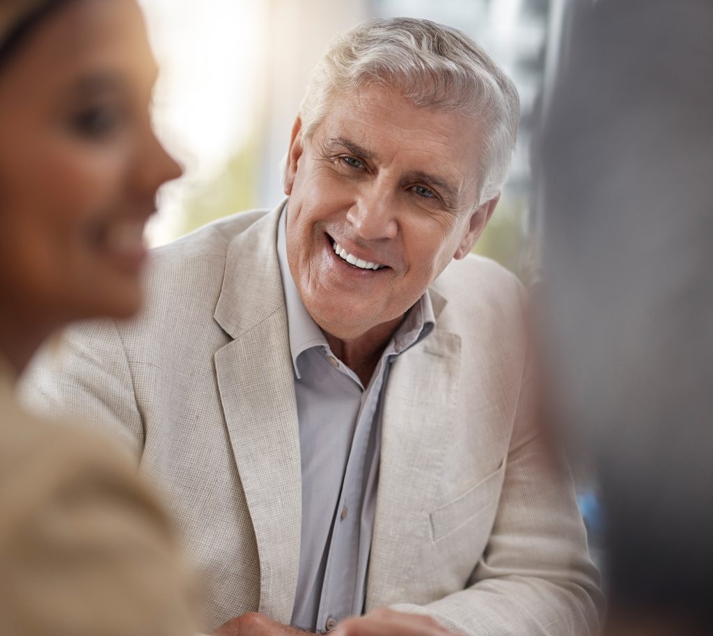 Face, smile a senior business man in the boardroom with his team for a meeting in discussion of str