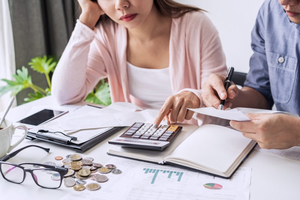 Stressed young couple calculating monthly home expenses and credit card bills payment